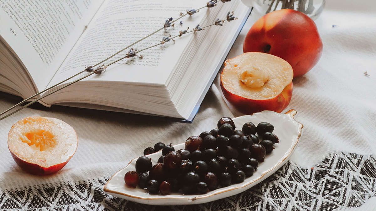 Aufgeschlagenes Buch, Nektarinen und Weintrauben