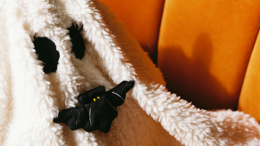 Flauschig weißes Monster auf orangenem Sofa.