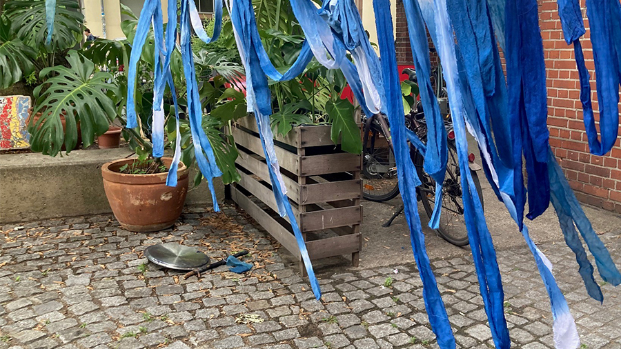 Blaue Stoffstreife hängen herunter auf dem Hof der Refo.
