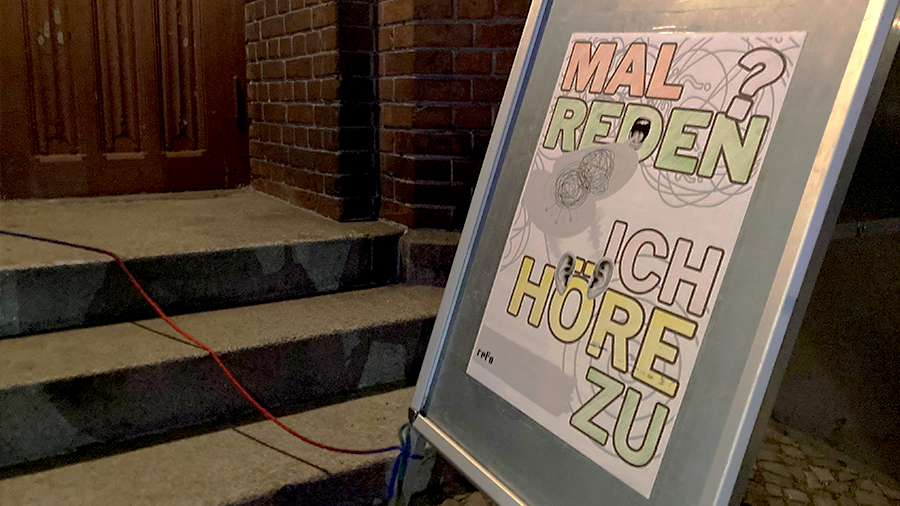 Aufsteller "Mal reden - Ich höre zu" vor Kirchentür