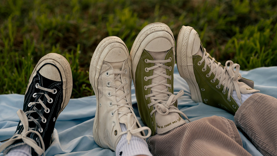 2 Paar Füße in Turnschuhen auf Wiese