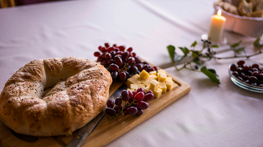 Bort, Trauben und Käse, brennende Kerze auf Tischtuch